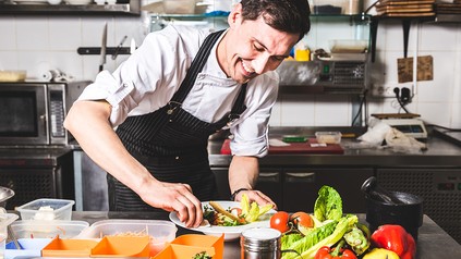 Koch schält Zucchini in der Küche