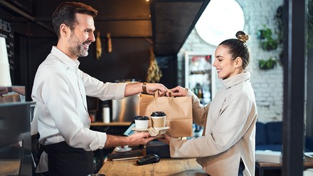 Gastronom gibt Essen zum Mitnahmen an Gast aus