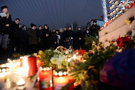 Trauernde Menschen vor Kerzen