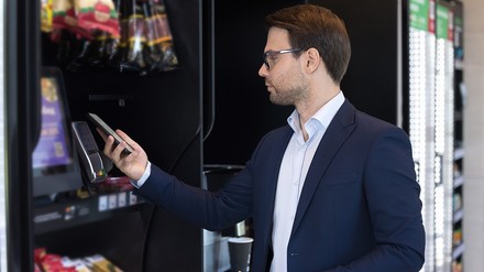 Mann kauft etwas am Vending-Automaten