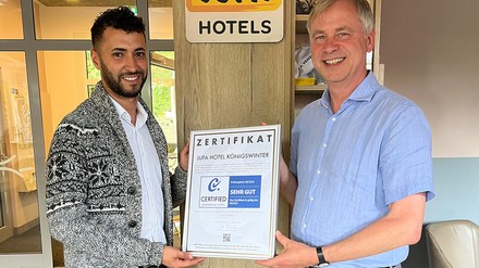 Till Runte überreicht Hoteldirektor Rachid Chouiri die Urkunde zur erfolgreichen Zertifizierung des Jufa Königswinter als „Certified Conference Hotel“.