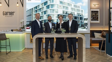 v.l.n.r.: Mario Maxeiner, David Etmenan, Karin Sheppard und Kenneth Macpherson feiern die Vertragsunterzeichnung während der Immobilienmesse Expo Real