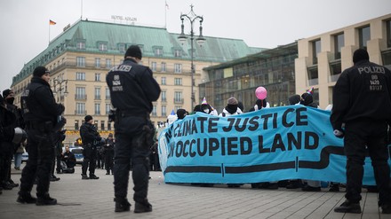 Polizeibeamte und Aktivisten stehen während Demonstrationen gegen den „World LNG Summit“ der Gasindustrie und Flüssiggasanbieter in Berlin vor dem Adlon.