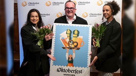 Wiesnchef Clemens Baumgärtner präsentiert mit den Künstlerinnen Amiera Harithas und Dianah-Charles Francis das offizielle Motiv zum Oktoberfest 2025.