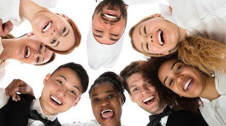 Junge Mitarbeiter der Gastronomie lachen gemeinsam in die Kamera