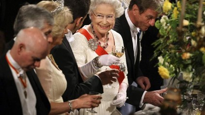 Die Queen stößt mit mehreren Personen an