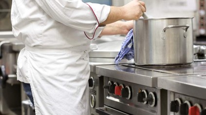 Ein Koch rührt in einem Topf