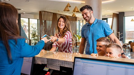 Familie beim Check-in im Hotel