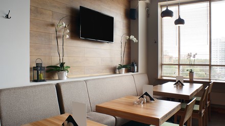 Leeres Restaurant, in dem ein Fernseher an der Wand hängt