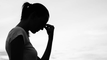 Eine verzweifelte Frau massiert sich die Augenlider