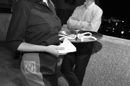 Eine Kellnerin serviert eine Vorspiese auf kleinen Löffeln