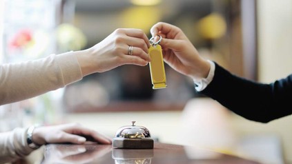 Frau übergibt anderer Frau Zimmerschlüssel