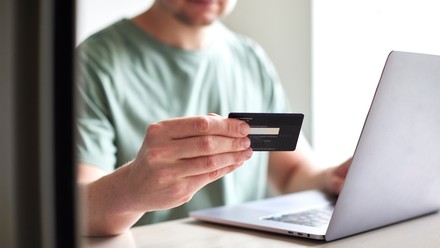 Mann bezahlt im Internet mit Kreditkarte