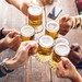 Mehrere Leute stoßen mit Bier an
