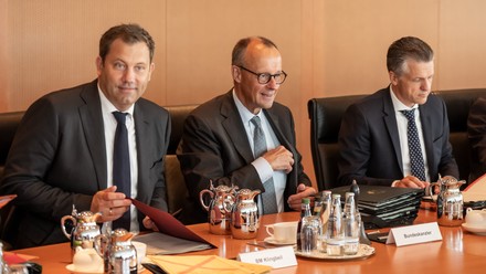 Lars Klingbeil (SPD) sitzt neben Bundeskanzler Friedrich Merz (CDU) und Thorsten Frei (CDU)