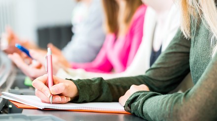 Weiterbildung, junge Frau macht sich Notizen