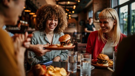 Kellner bringt Burger an den Tisch