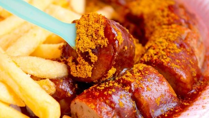 Eine Portion Currywurst mit Pommes
