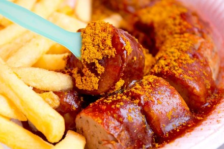 Eine Portion Currywurst mit Pommes