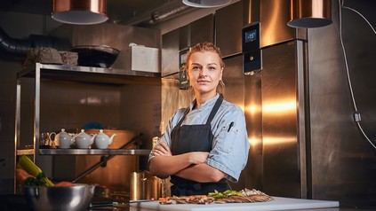 Junge Köchin mit verschränkten Armen