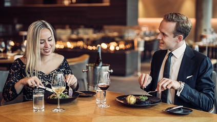 Ein Pärchen sitzt im Restaurant Terra im The Ritz-Carlton, Wolfsburg und isst das Weihnachtsmenü