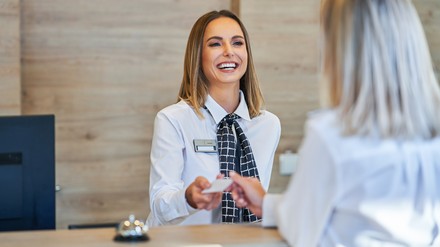 Rezeptionistin begrüßt Gast