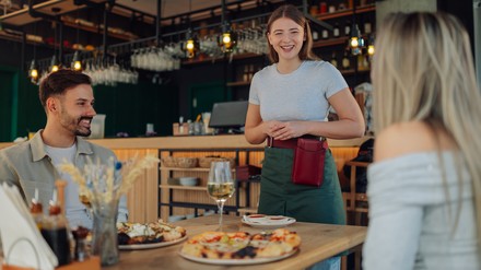 Kellnerin interagiert mit Gästen