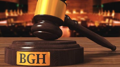 Ein Richterhammer ruht auf einer Holzplattform auf der BGH steht