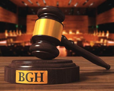 Ein Richterhammer ruht auf einer Holzplattform auf der BGH steht