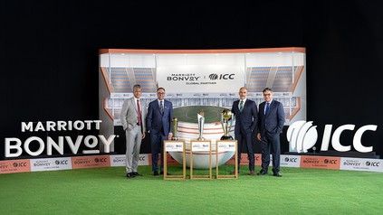 Repräsentanten von Marriott Bonvoy und dem International Cricket Council stehen vor einer Stadionkulisse mit Cricket-Pokalen bei der Vorstellung ihrer globalen Partnerschaft.