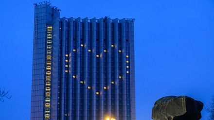 Licht in den Fenstern des Congress Hotels neben dem Karl-Marx-Monument in Chemnitz formen ein Herz.