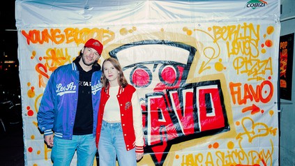 Die LionTaste-Gründer Lisa-Marie Noack und Johannes Reichenbach stehen vor einer besprühten Pop-up-Wand mit Pizza-Graffiti und Markenlogo.