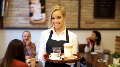 Eine junge Kellnerin serviert Kaffee