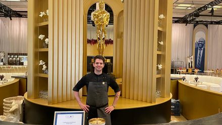 Bernhard Zimmerl steht in der Oscar-Küche in Los Angeles vor einer goldenen Oscar-Statue beim Governors Ball.