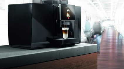 Eine moderne Kaffeemaschine poduziert einen Latte Macchiato