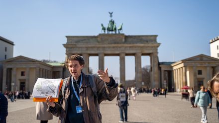 Stadtführer Leon Gordobil vom Tourenveranstalter Original Berlin Walks steht vor dem Brandenburger Tor.