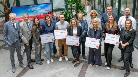 Gruppenfoto mehrerer Personen bei der Scheckübergabe der Initiative „Wir für Düsseldorf“ von Klüh zur Förderung von Seniorenprojekten in Düsseldorf