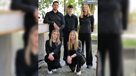Die Auszubildenden des Hotels Der Blaue Reiter stehen gemeinsam in der neu eröffneten „Bar am Schlossplatz“, die als Azubiprojekt umgesetzt wurde.