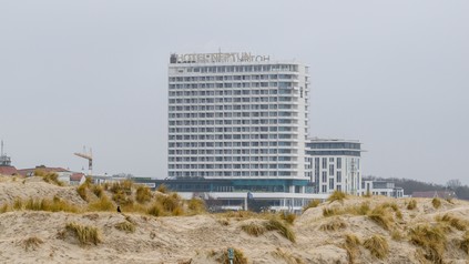 Hotel Neptun in Warnemünde hinter Dünen mit Strandgras