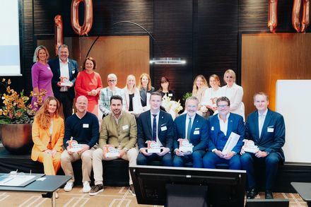 Partner von Fair Job Hotels stehen und sitzen bei der Auszeichnung zum zehnjährigen Jubiläum gemeinsam auf der Bühne.