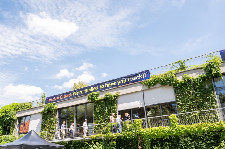Teilnehmer des UPNXT Hospitality Festivals 2026 tauschen sich auf der Außenfläche der Veranstaltungslocation in Berlin in lockerer Festivalatmosphäre aus.