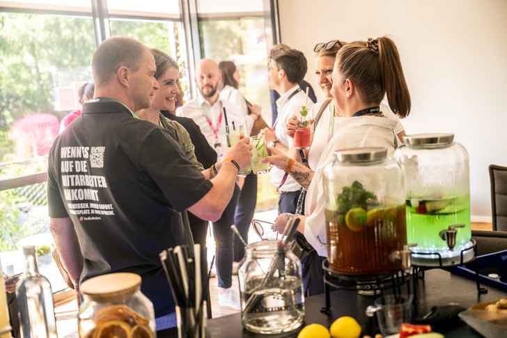 Teilnehmer des UPNXT Hospitality Festivals 2026 tauschen sich auf der Außenfläche der Veranstaltungslocation in Berlin in lockerer Festivalatmosphäre aus.