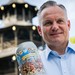 Christian Scharpf hält zwei offizielle Wirtekrüge für das Oktoberfest 2026 vor dem Chinesischen Turm in München