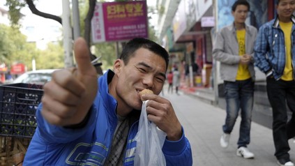 Mann isst auf Straße