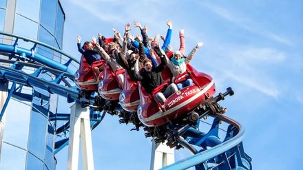Fahrgäste fahren mit erhobenen Armen in der Euro-Mir-Achterbahn im Europa-Park.