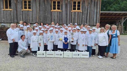Gemeinsam mit Markus Wasmeier feiern die Europa Miniköche ihren Weltrekord im Freilichtmuseum Schliersee und präsentieren stolz die Weltrekord-Urkunde.
