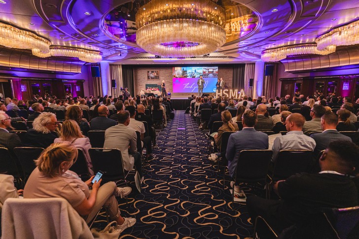 Blick in den voll besetzten Veranstaltungssaal des HSMAday 2025 mit beleuchteter Bühne und großem Publikum.