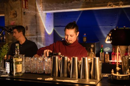 Bartender mixt während des Bar-Wars-Wettbewerbs einen Cocktail hinter der Bar.