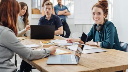 Eine Gruppe junger Menschen sitzt an einem Tisch und lernt