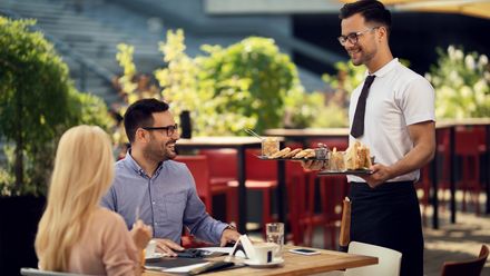 Kellner bringt Essen an den Tisch